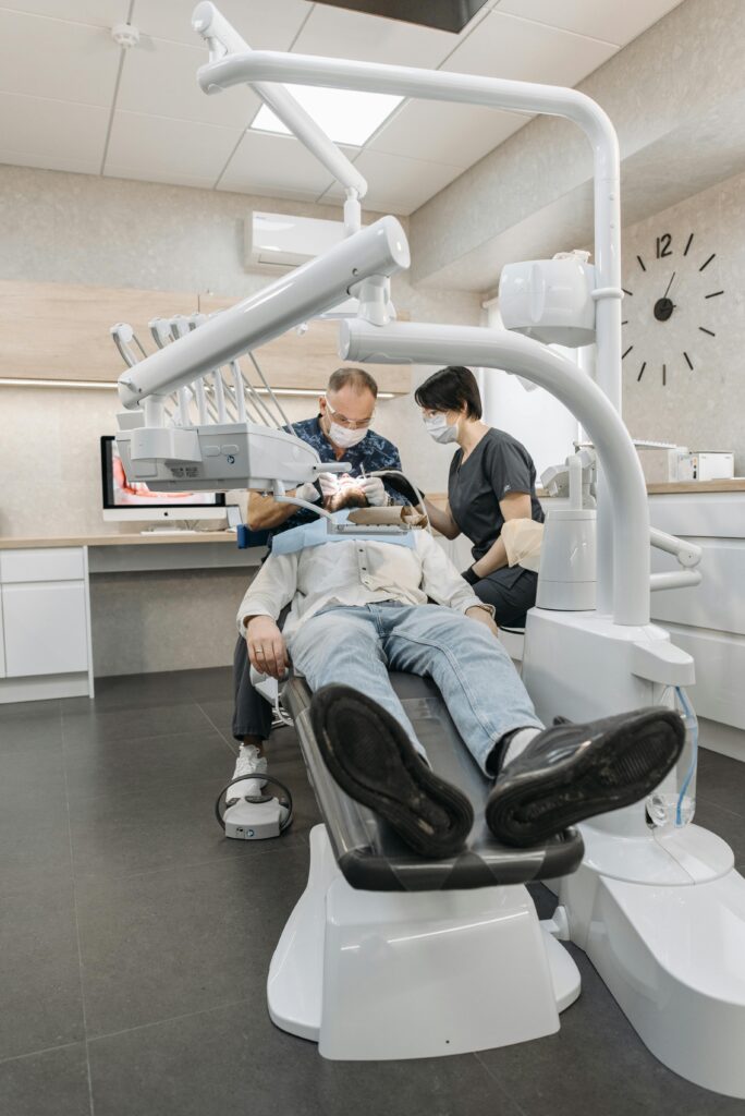 A dentist and assistant examine a patient at a modern dental clinic.